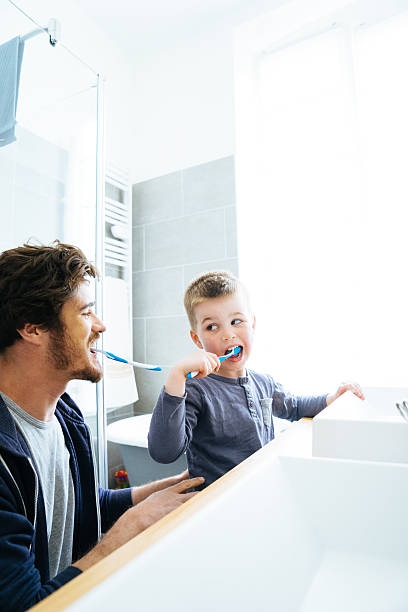 Father And Son Brushing Their Teeth stock photo