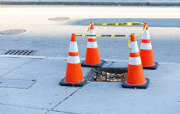 istock pothole on the sidewalk fenced 614211946