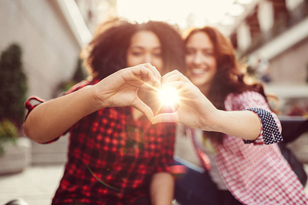 istock Mixed race girls showing heart shaped hands 614212054
