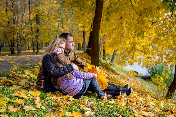Happy pregnant family in autumn nature stock photo