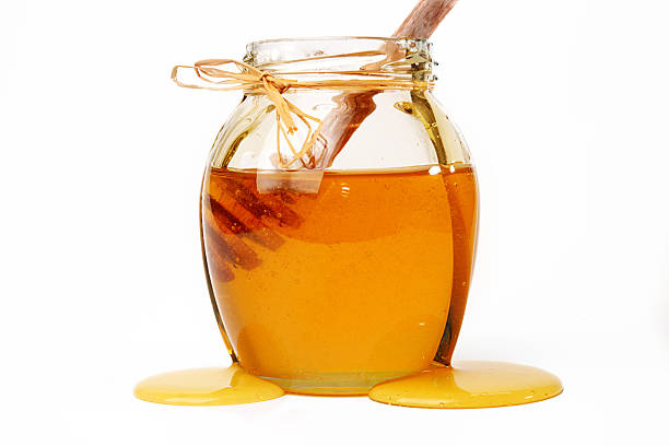 istock Honey and dipper in jar on white background. 614214848