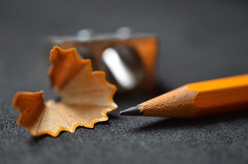 pencil with pencil shavings and pencil sharpener up close