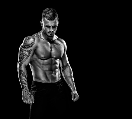 Portrait of a physically fit,tattooed  muscular young man without a shirt.