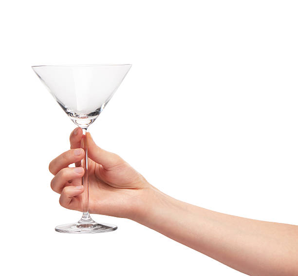 istock Female hand holding empty clean transparent martini glass 614217410