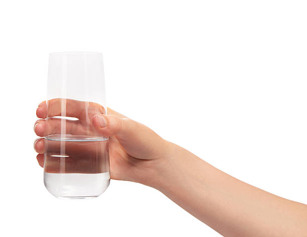 istock Female hand holding clean drinking glass with water 614217440