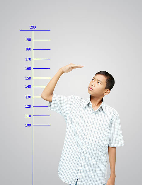 Young boy measuring his growth stock photo
