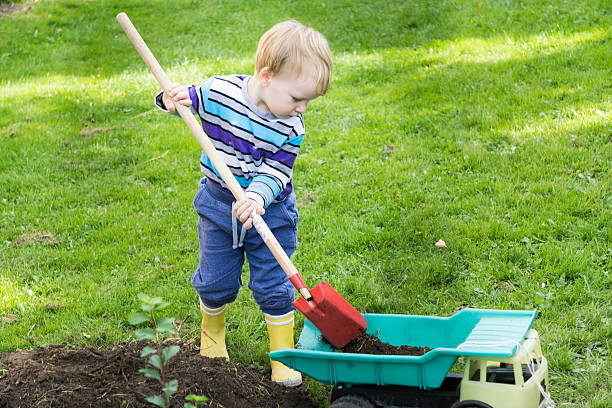 istock happy boy playing with car on a meadow 614220242