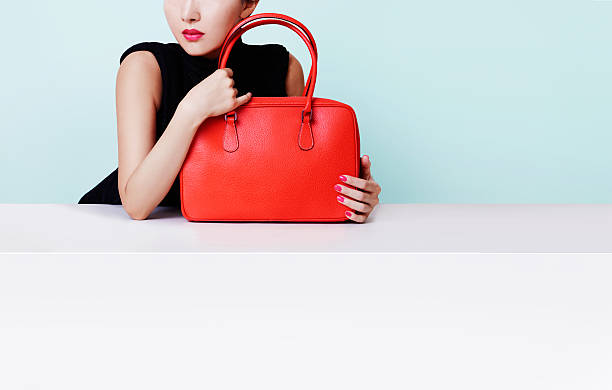 istock Woman holding red leather handbag. copy space. 614222054