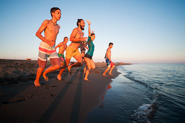 istock Friends running in to sea 614222852