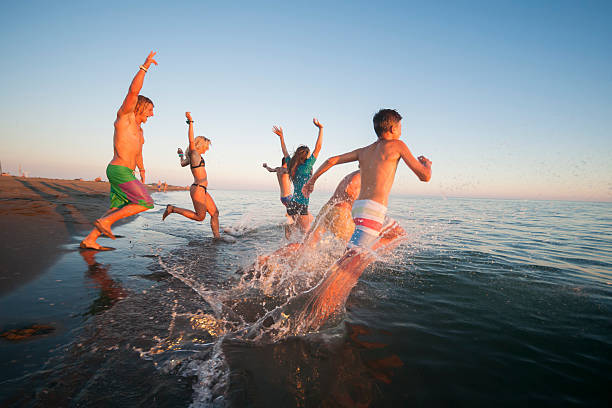 istock Friends running in to sea 614223104