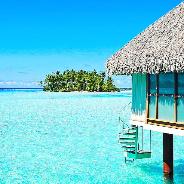 Beach in Maldives at sunset, wooden jetty and small shed. Exotic holiday destination