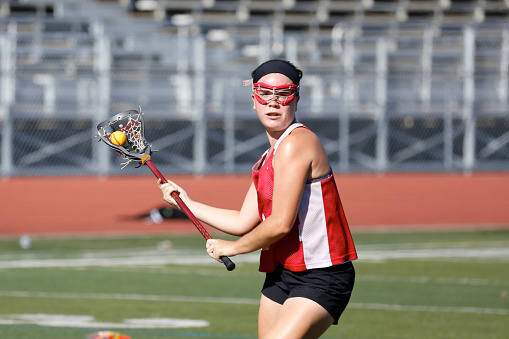 a girl prepares to throw a lacrosse ball