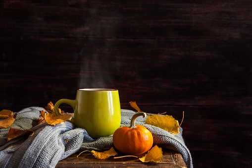 A cup of hot drink on a dark background. Autumn.