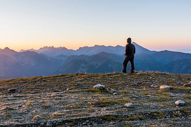 istock Hiker with trekking poles admire the sunrise. 614229314