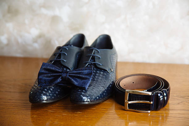 istock Groom accessories, bow-tie, shoes, strap on the table 614229556