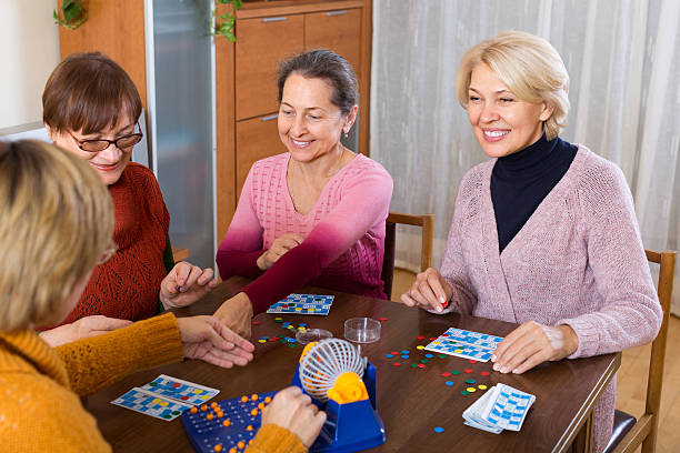 Mature women with table game Happy smiling female pensioners having fun with table game indoor dibs stock pictures, royalty-free photos & images