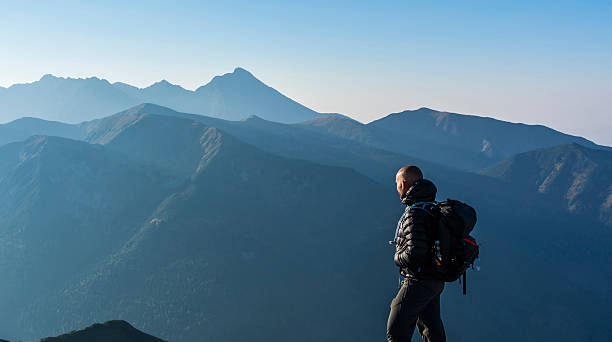 istock Hiker with backpack looking at a ridge in the morning. 614230148