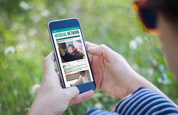 istock girl in grass holding her smartphone social network 614230890