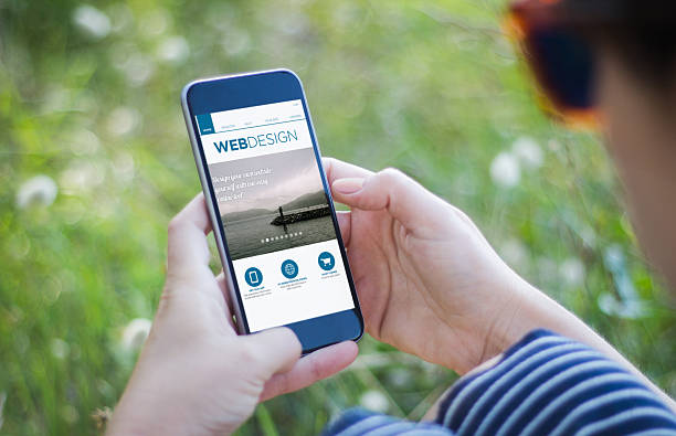 istock girl in grass holding her smartphone with web design interface 614231536