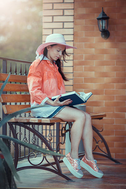 giovane ragazza hipster che legge il suo libro preferito - 20s adult camera caucasian foto e immagini stock