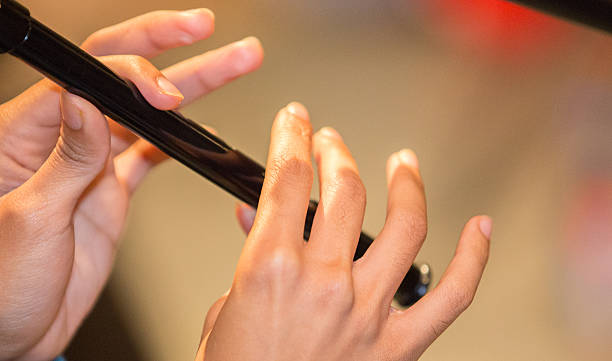 Musician playing a recorder / penny whistle two hands showing.