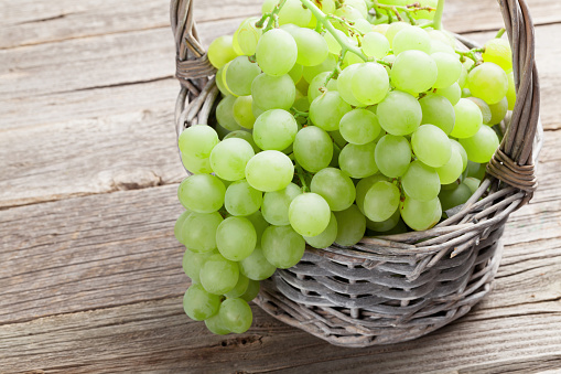 White grape in basket on wooden table