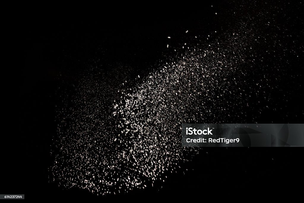 white dust debris isolated on black background white dust debris isolated on black background, motion powder spray burst in dark texture Flying Stock Photo