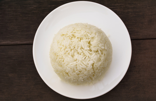 Cooked rice with plate isolated on Wood Table