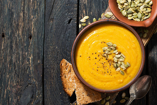 istock pumpkin soup with toasts, top view 614240290