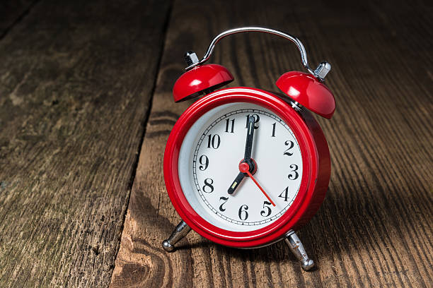 istock Red alarm clock on the wooden table 614240632