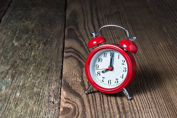 istock Red alarm clock on the wooden table 614240944
