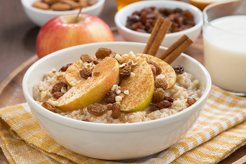 oatmeal with apples, raisins, cinnamon and ingredients, close-up, horizontal