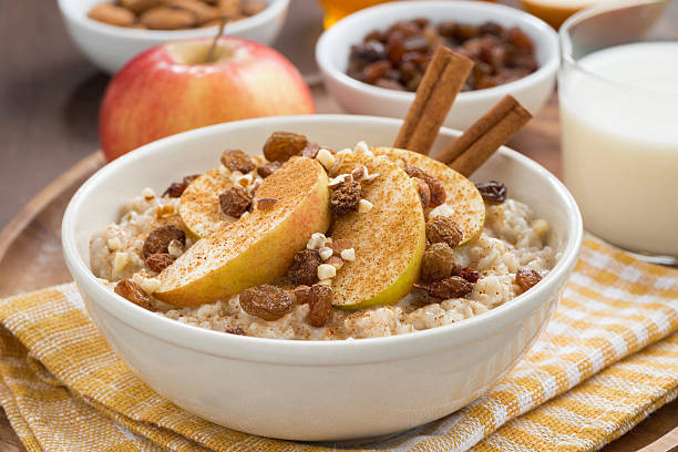 овсянка с яблоками, изюмом, корицей и ингредиентами, крупным планом - oatmeal porridge oat raisin стоковые фото и изображения