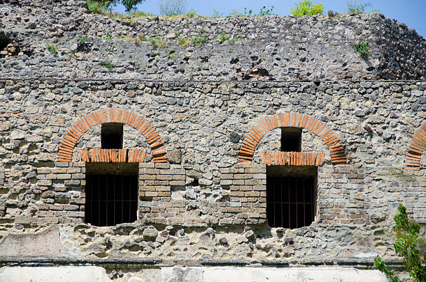 An exterior wall near the Porta Marina entrance in Pompeii showcase the amazing brick and rock work created in the city over 2,000 years ago.  The city, located near present day Naples, Italy, was first founded in the 7th century BC and became a cosmopolitan port city, reaching a population of over 11,000.  In 79 AD nearby Mount Vesuvius erupted violently, catching many citizens unaware, and depositing over 20 feet of ash and pumice across the region.  People were frozen in time, encapsulated by the ash and preserved for 1,500 years until portions of the city were excavated.  Plaster was used to fill the voids where human beings had been trapped, giving present day visitors a detailed example of what life was like on the day of the eruption.  Preserved were a remarkable water system (aquaducts), an amphitheater, forum and theater, villas with colorful fresco paintings, public baths, temples, and various businesses.