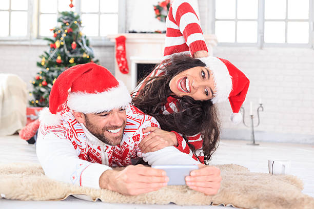 jeune couple s’mentant sur le devant et faisant du selfie à la maison - global warming flash photos et images de collection