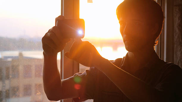 istock Young businessman taking picture with mobile phone against panoramic window 614245568