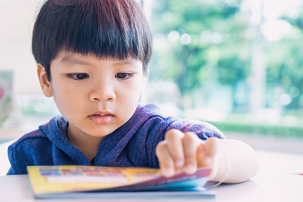 istock Japanese boy is reading a educational play book. 614248896