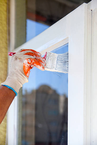 istock Man painting frame of the window 614250570