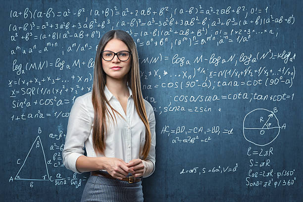 jeune femme d’affaires debout sur le fond du tableau noir avec mathématique - formula blackboard complexity scientist photos et images de collection