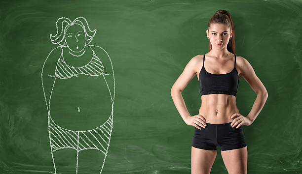 Sporty girl with slim body and picture of fat woman Sporty girl with a slim body standing at the right side and a picture of a fat woman drawn at the left side on a green chalkboard background. Getting rid of a pot belly. Losing weight. Before and after. before and after weight loss stock pictures, royalty-free photos & images