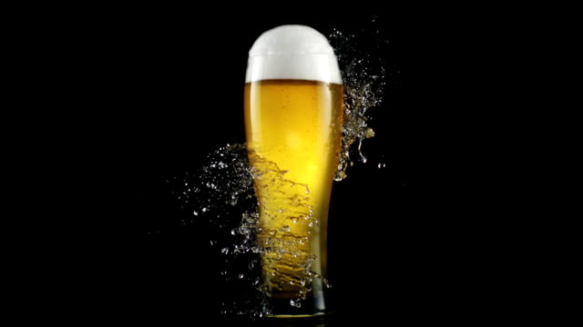 Drops of water crashing on a glass full of beer. Freshness metaphor