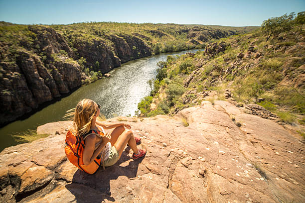 mujer excursionista en la cima del acantilado mira a la vista - catherine park fotografías e imágenes de stock