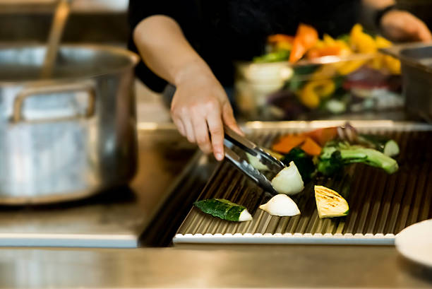 istock Chef cooking vegetables on the grill 614304360
