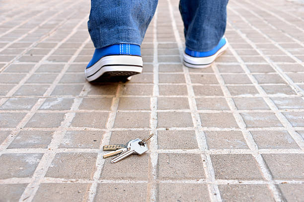 losing my keys Cropped rear view of a walking young who loses the home keys on the sidewalk street in the city falling behind stock pictures, royalty-free photos & images