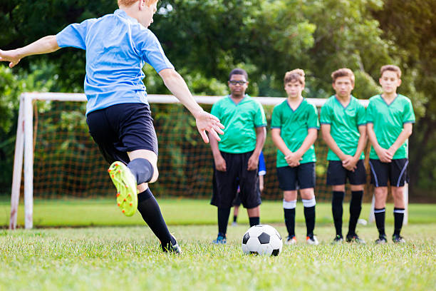 istock Boy takes penalty shot during soccer game 614306522