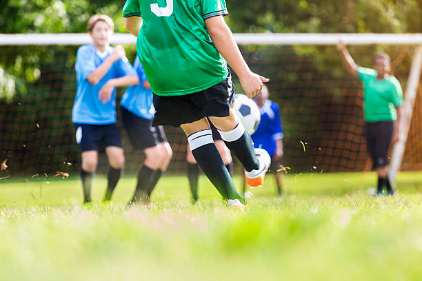 istock Boy kicks ball during soccer game 614306580