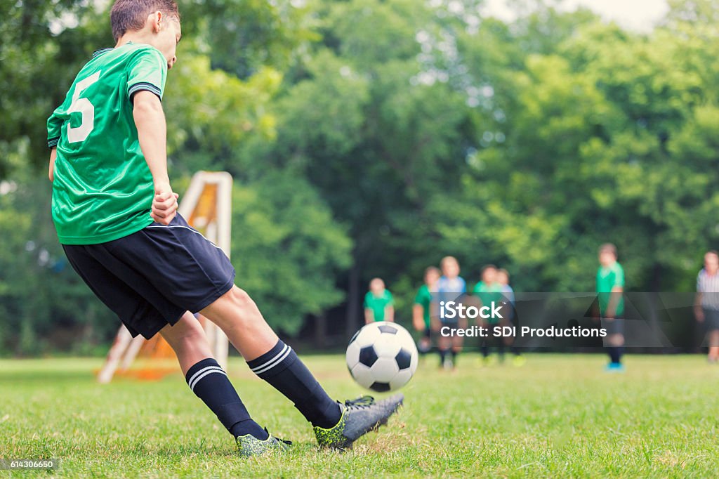 Caucasian soccer player kicks ball - Royalty-free Voetbal - Teamsport Stockfoto