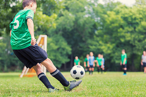 Caucasian soccer player kicks ball