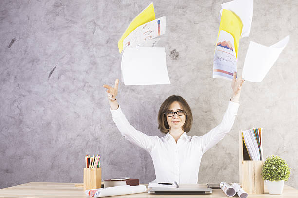 istock Businesswoman throwing papers in office 614307652