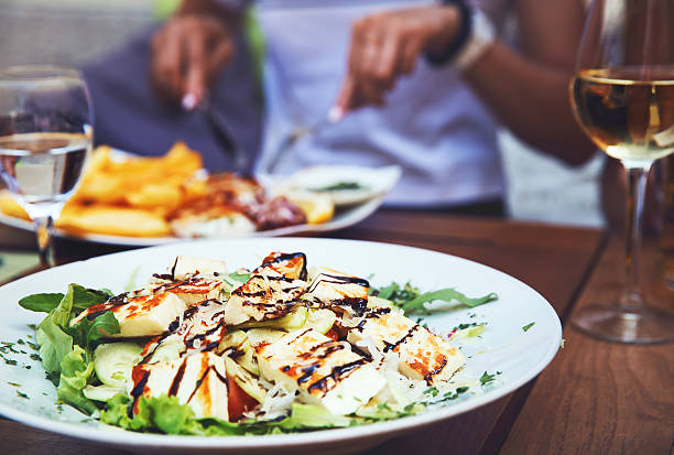 Dinner at restaurant. Dinner at restaurant. Close-up salad with grilled cheese.  People eating on the background istria photos stock pictures, royalty-free photos & images